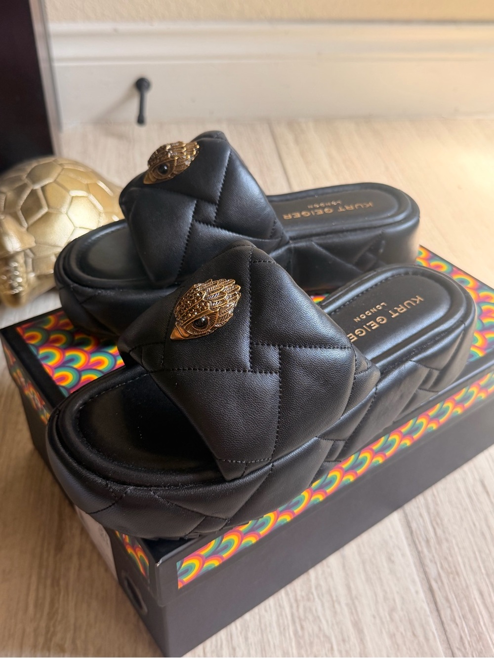 Kurt Geiger Black Quilted Slide Mules with Gold Eye Accent
